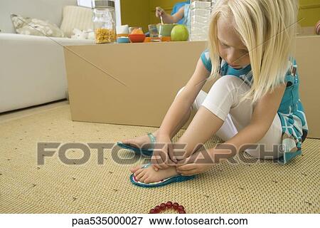Little girl putting on sandal View Large Photo Image Stock Photo - Little girl putting on sandal. Fotosearch