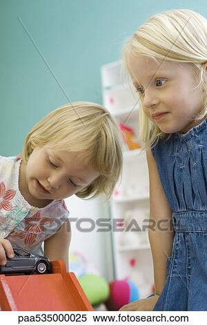 Little girls playing with toy car View Large Photo Image Stock Photography - Little girls playing with toy car. Fotosearch
