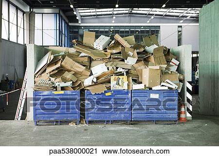 Stock Image - Bins overflowing with cardboard in recycling center. Fotosearch