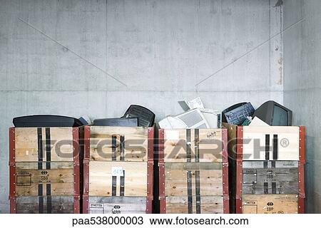 Stock Image - Discarded electronics in crates stacked in recycling center. Fotosearch