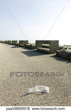 Stock Photo - Discarded food package on sidewalk. Fotosearch