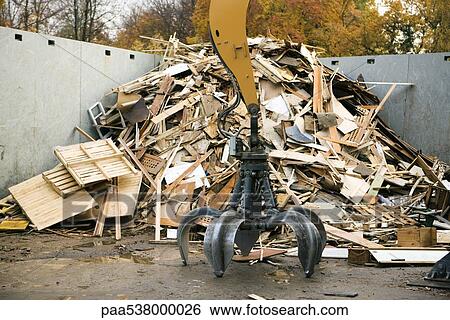 Grapple in front of large heap of scrap wood in recycling center View Large Photo Image Stock Photograph - Grapple in front of large heap of scrap wood in recycling center. Fotosearch