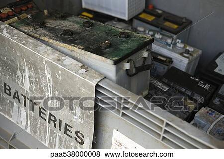 Stock Photo - Old car batteries stacked in recycling bin. Fotosearch