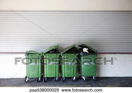 Overflowing garbage cans in a row View Large Photo Image Stock Photo - Overflowing garbage cans in a row. Fotosearch