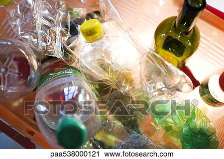 Stock Image - Plastic and glass bottles in recycling bin, close-up. Fotosearch