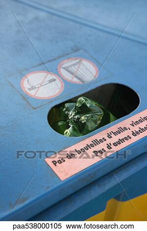 Stock Photography - Plastic bottle sticking out of full recycling bin, close-up. Fotosearch