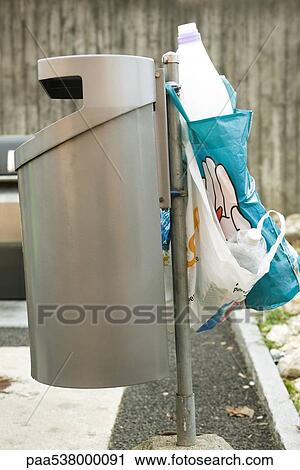 Plastic bottles in bags hanging off trash can View Large Photo Image Stock Image - Plastic bottles in bags hanging off trash can. Fotosearch