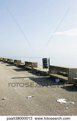 Stock Image - Trash scattered along pier. Fotosearch