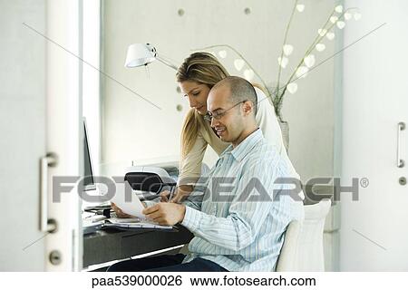Stock Photograph - Couple working in home office. Fotosearch
