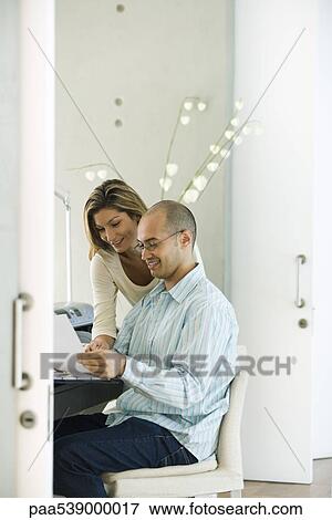Stock Photo - Couple working together in home office. Fotosearch