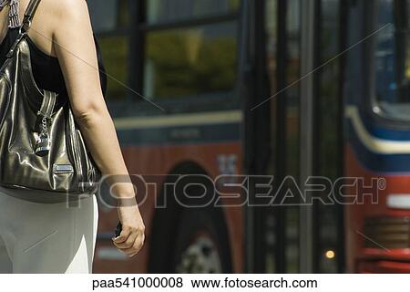 Woman waiting in front of bus, cropped View Large Photo Image Stock Photo - Woman waiting in front of bus, cropped. Fotosearch