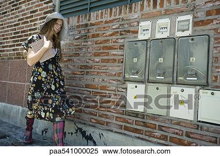 Young woman in trendy clothing walking on sidewalk View Large Photo Image Stock Photography - Young woman in trendy clothing walking on sidewalk. Fotosearch