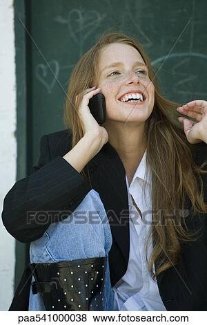 Young woman talking on cell phone, playing with hair View Large Photo Image Stock Photo - Young woman talking on cell phone, playing with hair. Fotosearch