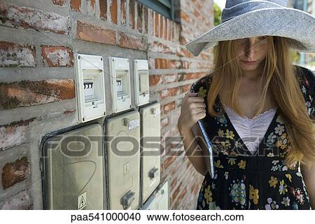 Young woman wearing large hat, looking down View Large Photo Image Stock Image - Young woman wearing large hat, looking down. Fotosearch