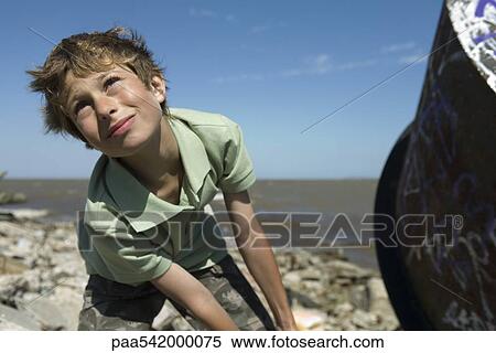 Boy on polluted shore, pulling large piece of scrap metal, close-up View Large Photo Image Stock Photography - Boy on polluted shore, pulling large piece of scrap metal, close-up. Fotosearch