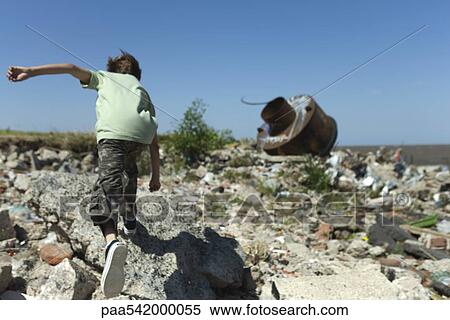Boy running on shore littered with debris View Large Photo Image Stock Photography - Boy running on shore littered with debris. Fotosearch