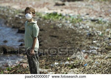 Boy standing on polluted shore, wearing pollution mask View Large Photo Image Stock Photo - Boy standing on polluted shore, wearing pollution mask. Fotosearch