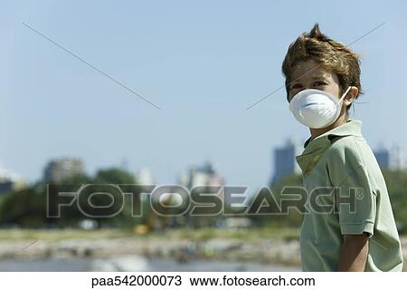 Boy standing outdoors, wearing pollution mask View Large Photo Image Stock Image - Boy standing outdoors, wearing pollution mask. Fotosearch