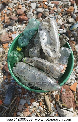 Stock Photo - Discarded plastic bottles in garbage can. Fotosearch