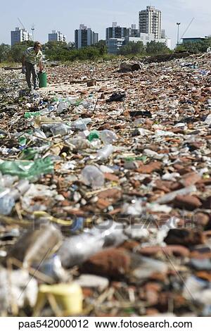 Male collecting trash in polluted landscape View Large Photo Image Stock Image - Male collecting trash in polluted landscape. Fotosearch