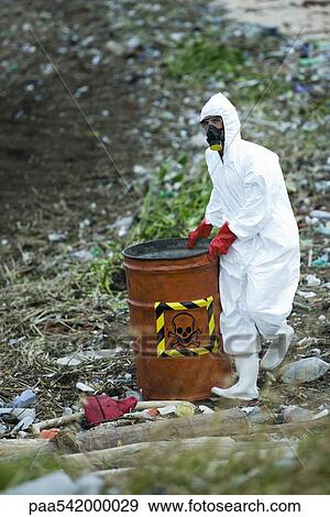 Person in protective suit carrying barrel of hazardous waste View Large Photo Image Stock Photo - Person in protective suit carrying barrel of hazardous waste. Fotosearch