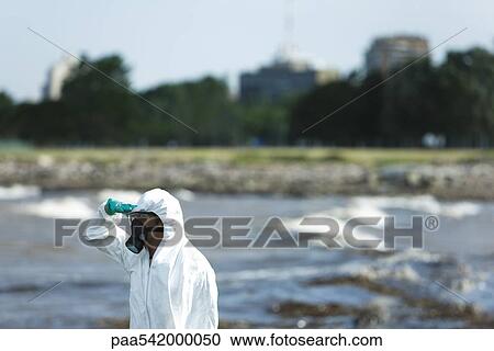 Person in protective suit looking at polluted water, side view View Large Photo Image Stock Image - Person in protective suit looking at polluted water, side view. Fotosearch