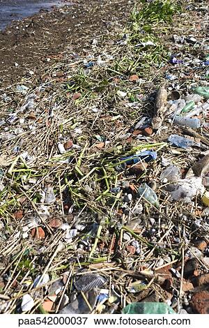 Shore littered with trash and debris View Large Photo Image Stock Photo - Shore littered with trash and debris. Fotosearch