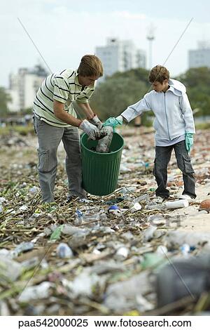 Two people in garbage dump, collecting recyclable plastic materials in garbage can View Large Photo Image Stock Photography - Two people in garbage dump, collecting recyclable plastic materials in garbage can. Fotosearch