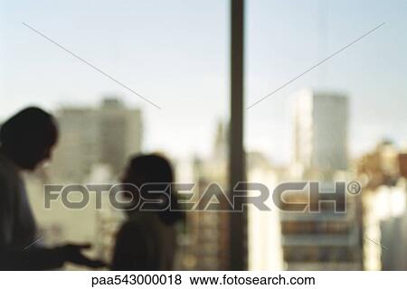 Stock Photo - Man and woman face to face having conversation, window behind, silhouette. Fotosearch