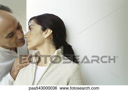 Mature couple, man with hand on wife's shoulder leaning down to kiss her View Large Photo Image Stock Photograph - Mature couple, man with hand on wife's shoulder leaning down to kiss her. Fotosearch