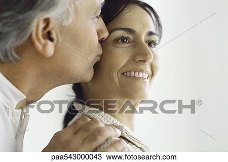 Mature woman, husband kissing her cheek from behind View Large Photo Image Stock Image - Mature woman, husband kissing her cheek from behind. Fotosearch