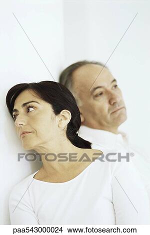 Picture - Mature woman leaning against husband, both looking away. Fotosearch