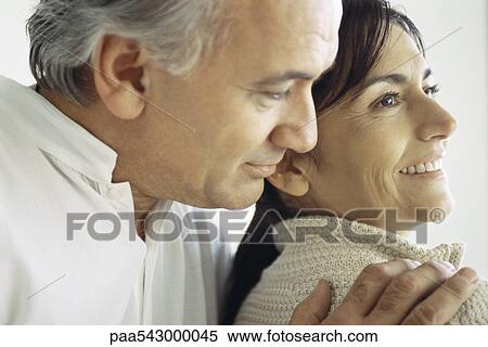 Stock Photography - Senior man embracing wife from behind, close-up. Fotosearch