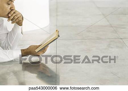 Senior man lying on tiled floor reading book View Large Photo Image Stock Photograph - Senior man lying on tiled floor reading book. Fotosearch