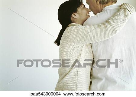 Woman embracing husband, smiling at him View Large Photo Image Picture - Woman embracing husband, smiling at him. Fotosearch