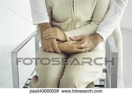 Stock Photo - Woman sitting, man embracing from behind, cropped. Fotosearch
