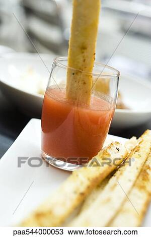 Breadstick dipped in spicy sauce View Large Photo Image Stock Image - Breadstick dipped in spicy sauce. Fotosearch