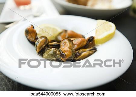 Steamed mussels garnished with lemon slices View Large Photo Image Stock Photography - Steamed mussels garnished with lemon slices. Fotosearch
