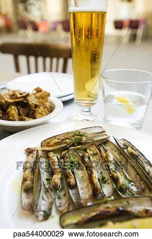 Steamed razor clams, glass of beer View Large Photo Image Stock Photo - Steamed razor clams, glass of beer. Fotosearch
