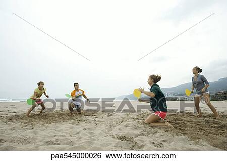 Teen friends playing paddleball on beach View Large Photo Image Stock Photograph - Teen friends playing paddleball on beach. Fotosearch