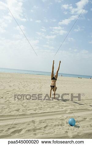 Teen girl doing handstand on beach View Large Photo Image Stock Image - Teen girl doing handstand on beach. Fotosearch