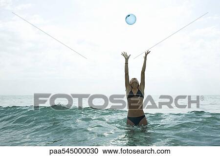 Teen girl in sea with arms raised to catch ball View Large Photo Image Stock Image - Teen girl in sea with arms raised to catch ball. Fotosearch