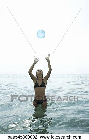 Teen girl standing in sea, catching ball View Large Photo Image Stock Image - Teen girl standing in sea, catching ball. Fotosearch