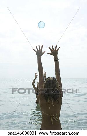 Teen girls playing with beach ball in sea View Large Photo Image Stock Image - Teen girls playing with beach ball in sea. Fotosearch
