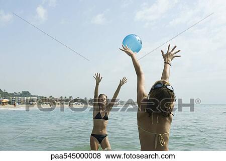 Teen girls playing with beach ball in sea View Large Photo Image Stock Photo - Teen girls playing with beach ball in sea. Fotosearch