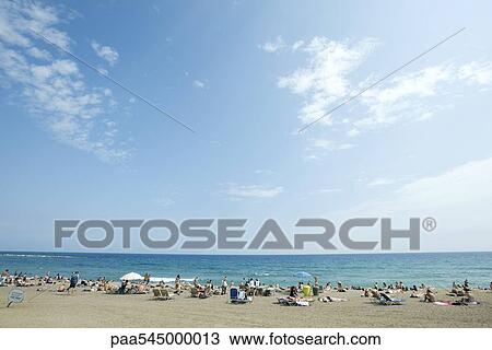 Stock Image - Vacationers on beach. Fotosearch
