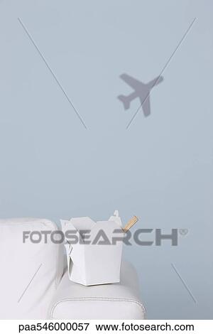 Box of Chinese take-out on arm of sofa, airplane shape in background View Large Photo Image Stock Photo - Box of Chinese take-out on arm of sofa, airplane shape in background. Fotosearch