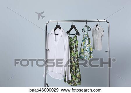 Family's summer clothing hanging on clothes rack, airplane shape in background View Large Photo Image Stock Photo - Family's summer clothing hanging on clothes rack, airplane shape in background. Fotosearch