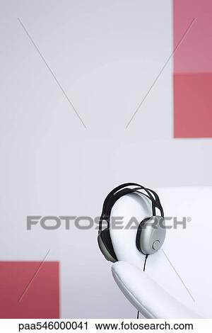 Stock Image - Headphones on arm of armchair. Fotosearch