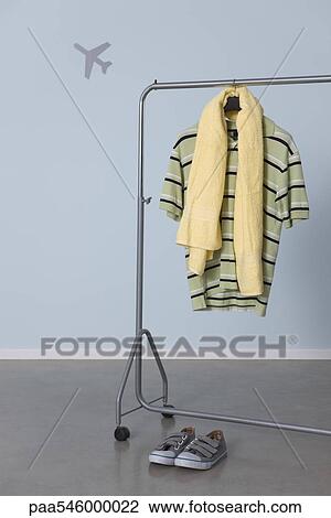 Man's casual clothes hanging on clothes rack, airplane graphic in background View Large Photo Image Stock Image - Man's casual clothes hanging on clothes rack, airplane graphic in background. Fotosearch